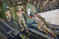 Aerial porters from the Kentucky Air National Guard’s 123rd Logistics Readiness Squadron work with their active-duty and civilian counterparts from the 735th Air Mobility Squadron to load a shipping container onto a U.S. Air Force C-17 Globemaster II at Joint Base Pearl Harbor-Hickam, Hawaii, on Aug. 5, 2025.