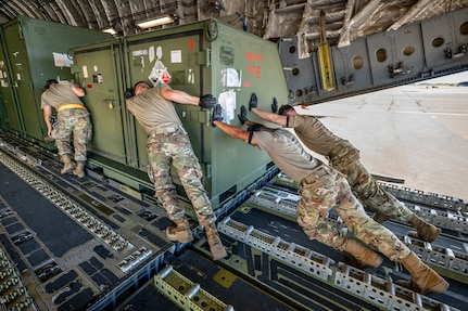 Aerial porters from the Kentucky Air National Guard’s 123rd Logistics Readiness Squadron work with their active-duty and civilian counterparts from the 735th Air Mobility Squadron to load a shipping container onto a U.S. Air Force C-17 Globemaster II at Joint Base Pearl Harbor-Hickam, Hawaii, on Aug. 5, 2025.