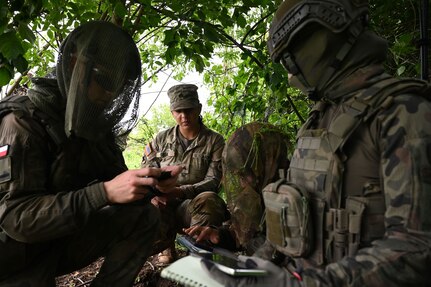 U.S. Army Sgt. Joseline Sosa, a forward observer with 1st Battalion, 178th Infantry Regiment, Illinois Army National Guard, relays information to her Polish Territorial Defence Force counterparts during remote observer training in Toruń, Poland, June 6, 2025.