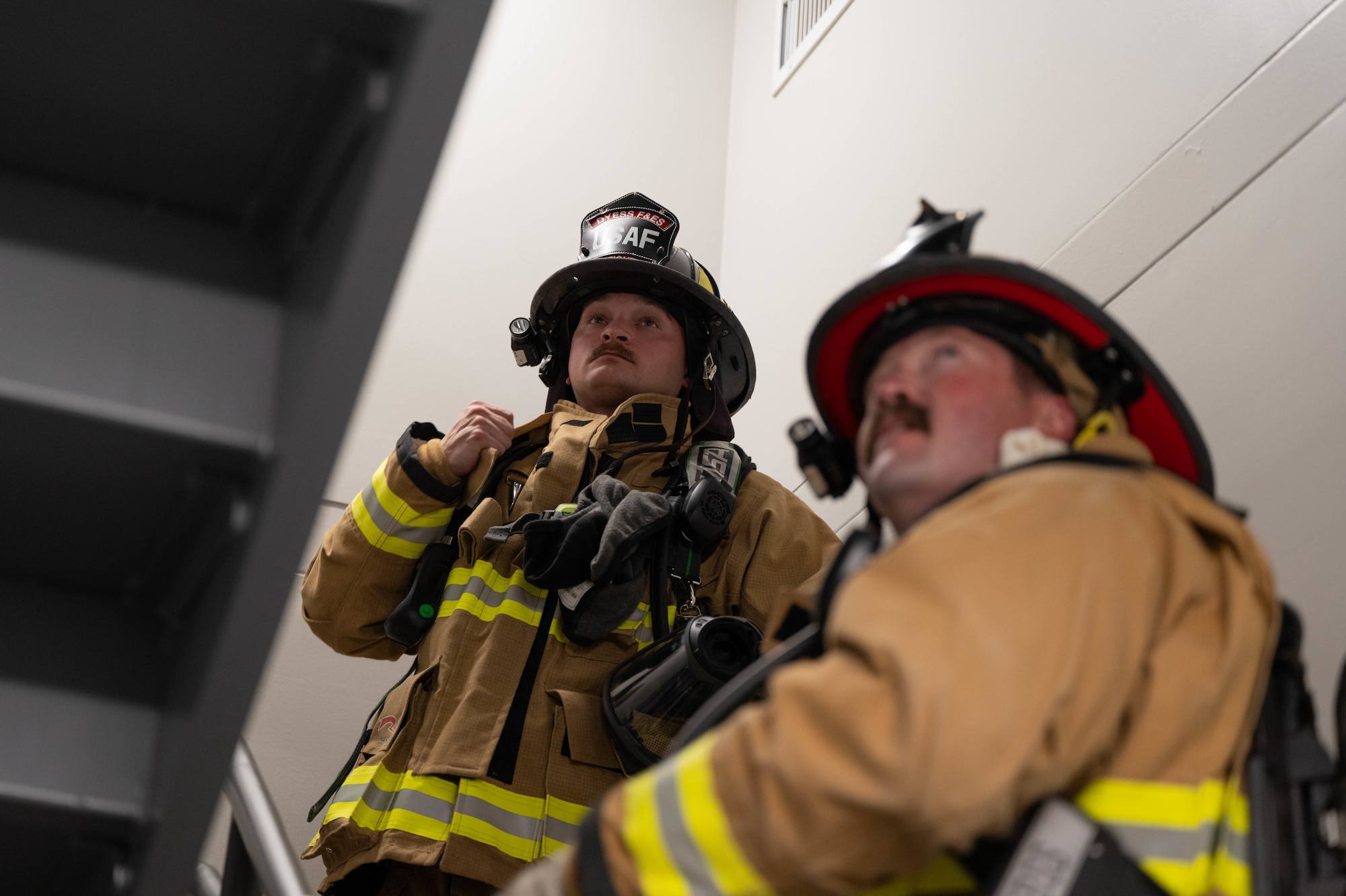 A firefighter in a fire suit coordinates emergency response while outside.