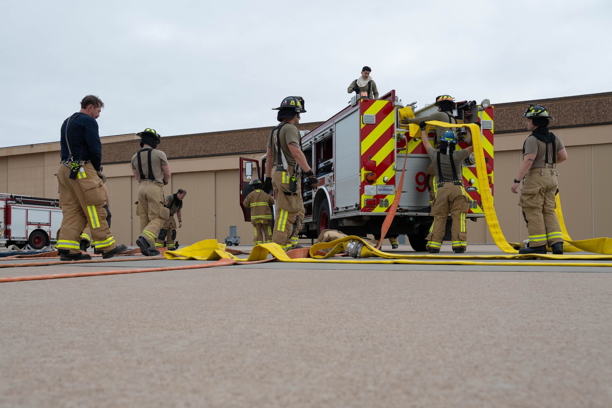 A firefighter in a fire suit coordinates emergency response while outside.