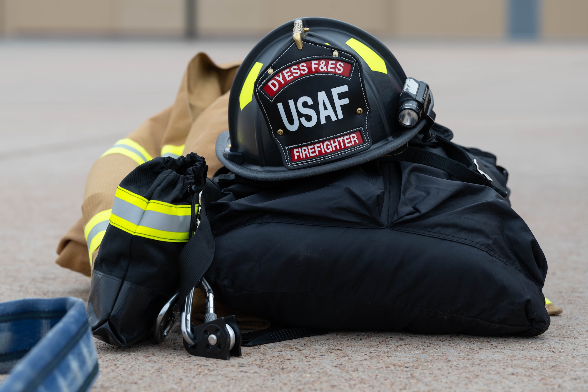 A firefighter in a fire suit coordinates emergency response while outside.
