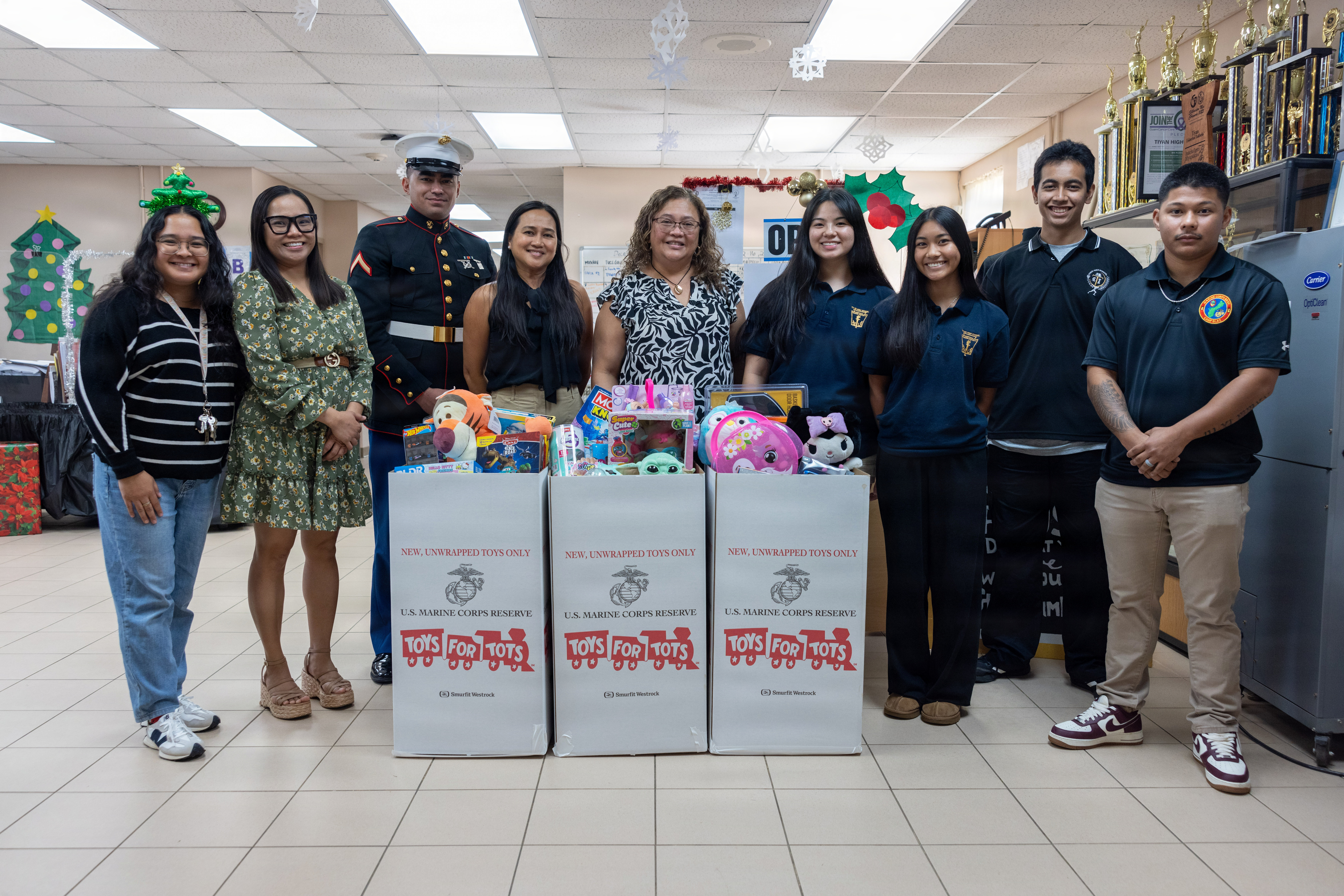 U.S. Marines with Marine Corps Base Camp Blaz pose with Tiyan High School students and staff for a photo for the Toys for Tots 2025 campaign at Tiyan High School, Barrigada, Guam, Dec. 16, 2025. Toys for Tots was founded in 1947 and has grown into a Marine Corps Reserve nationwide program that brings holiday joy to millions of underprivileged children each year. (U.S. Marine Corps photo by Lance Cpl. Rey Moreno Marilao)