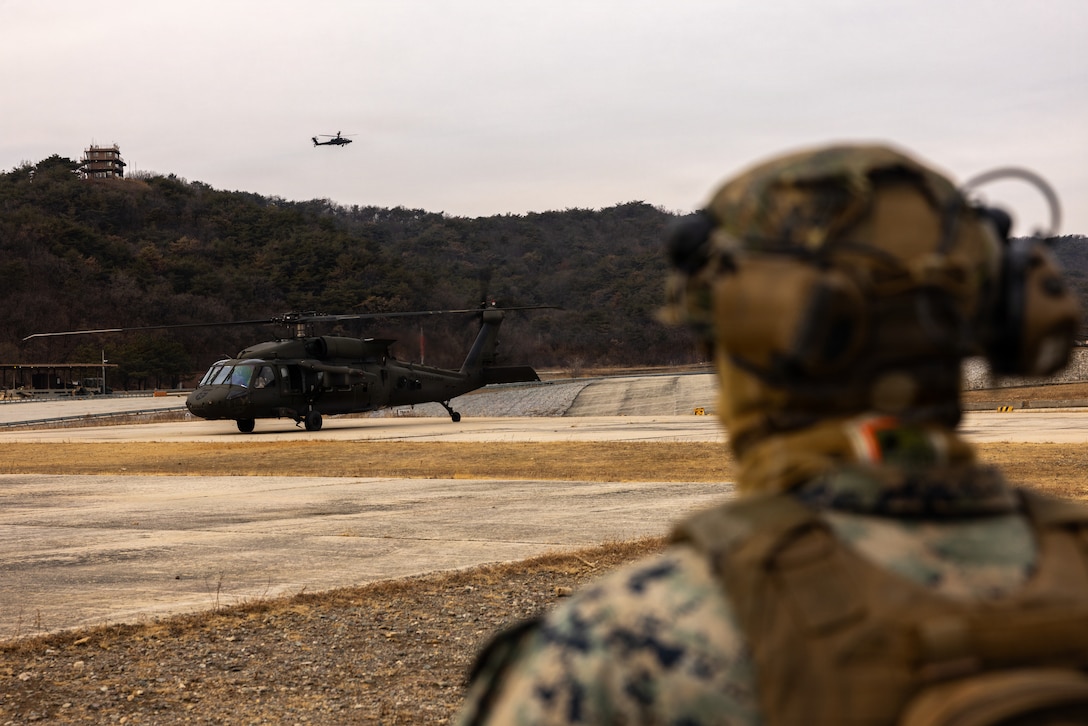 A U.S. Marine with 1st Battalion, 6th Marines, forward deployed with 4th Marine Regiment, 3rd Marine Division as part of the Unit Deployment Program, prepares to conduct a flyaway drill in a UH-60 Black Hawk helicopter alongside U.S. Army Soldiers with 2nd Battalion, 2nd Aviation Regiment, 2nd Combat Aviation Brigade during Korea Viper 26.1 at Camp Rodriguez, South Korea, Dec. 12, 2025.