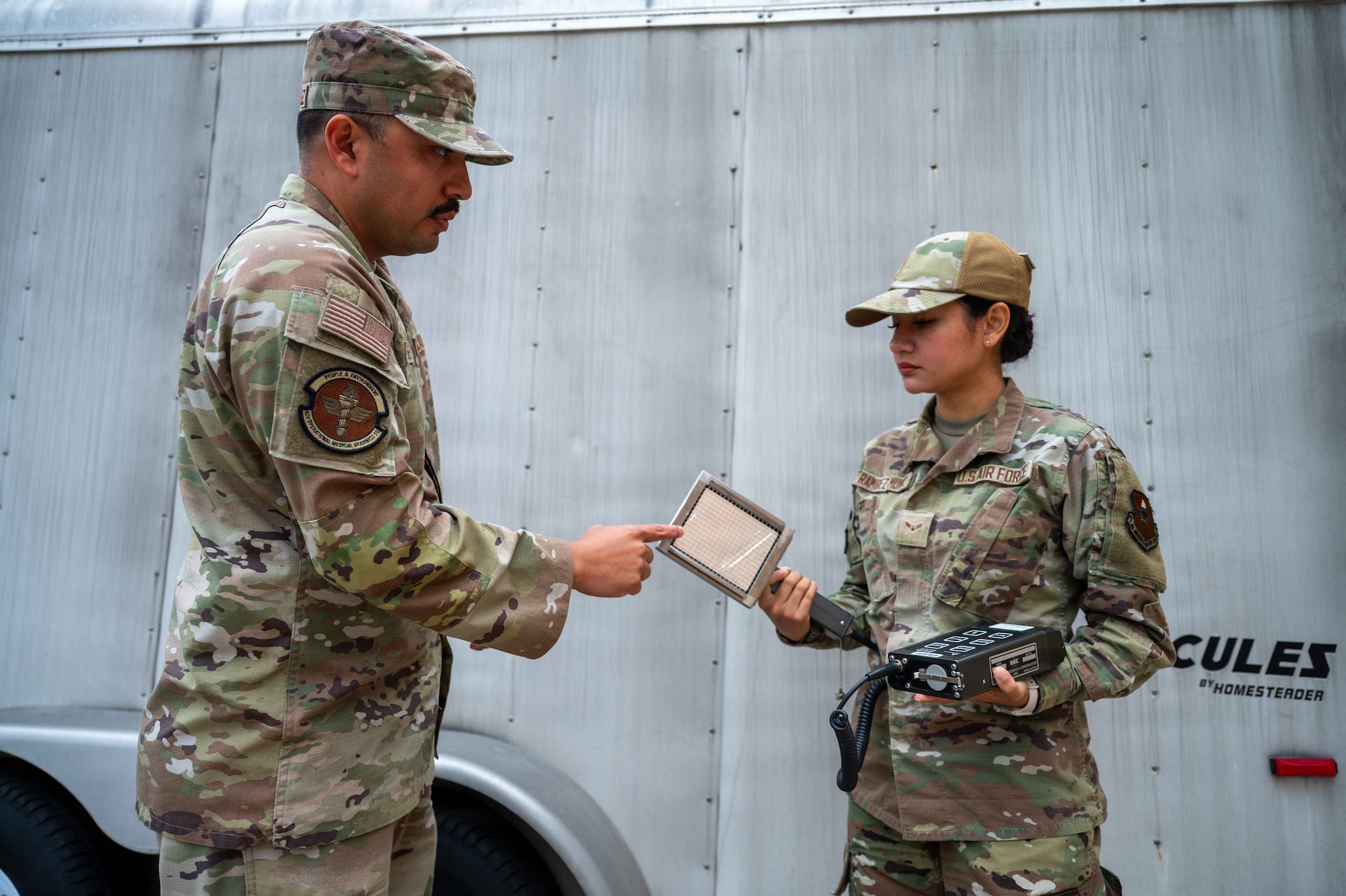 U.S. Air Force Tech. Sgt. Hector Mendez-Chavez, bioenvironmental engineering flight chief, Maxwell Medical Group, instructs Airman 1st Class Arely Ramirez-Munoz, bioenvironmental engineering technician, on how to set up and operate radiation detection equipment at Maxwell Air Force Base, Alabama, Oct. 30, 2025. The equipment is used by the bioenvironmental engineering flight to collect radiation and determine the concertation of contamination in the air. (U.S. Air Force photo by Senior Airman Evan Porter)