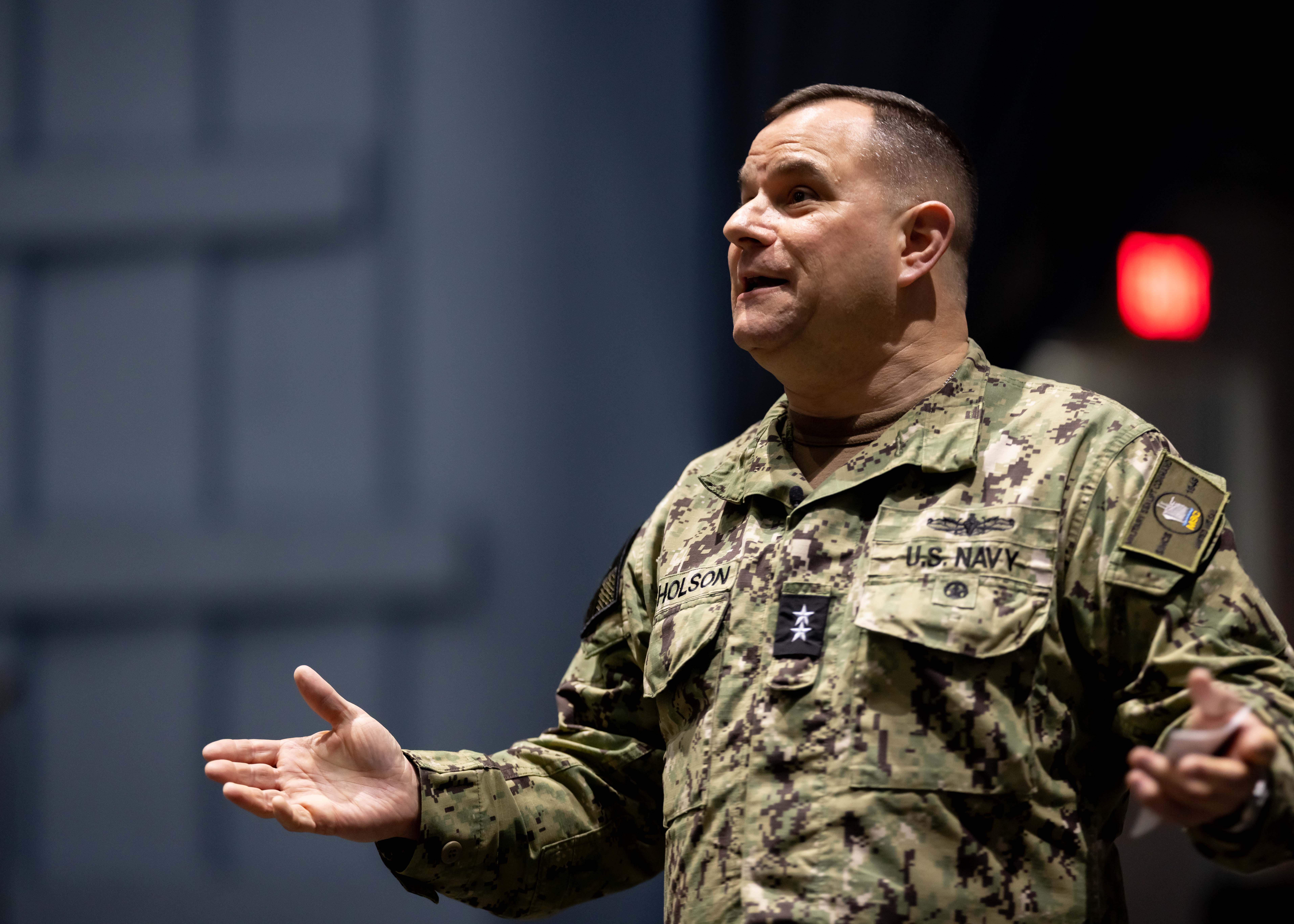 Rear Adm. Benjamin R. Nicholson, Commander, Military Sealift Command (MSC), delivers remarks during an all-hands call at Naval Station Norfolk, Dec. 18, 2025. MSC directs and supports operations for approximately 140 civilian-crewed ships that replenish U.S. Navy ships at sea, conduct specialized missions, preposition combat cargo at sea around the world, perform a variety of support services, and move military equipment and supplies to deployed U.S. forces.