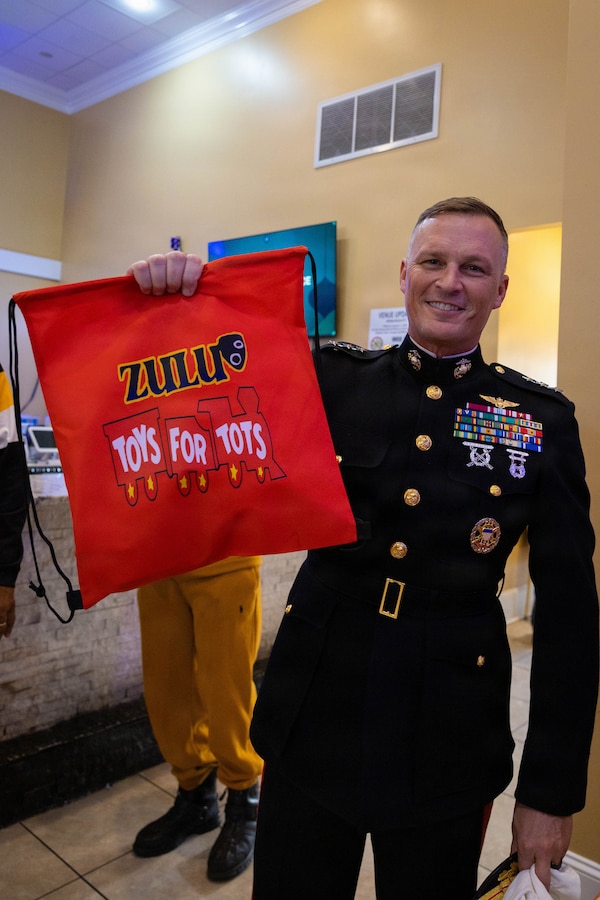 U.S. Marine Corps Lt. Gen. Leonard F. Anderson IV, commander of Marine Forces Reserve and Marine Forces South, poses for a photo with merchandise provided by the Zulu Social Aid and Pleasure Club during a Toys for Tots event at the Zulu Social Aid and Pleasure Club in New Orleans, Dec. 20, 2025. The Zulu Social Aid and Pleasure Club, New Orleans’ largest predominantly African American Carnival organization, hosted a Toys for Tots event open to the local community of New Orleans, where attendees received gifts provided by the Marine Corps and fellow members of the community. (U.S. Marine Corps photo by Lance Cpl. Claire Cheney)