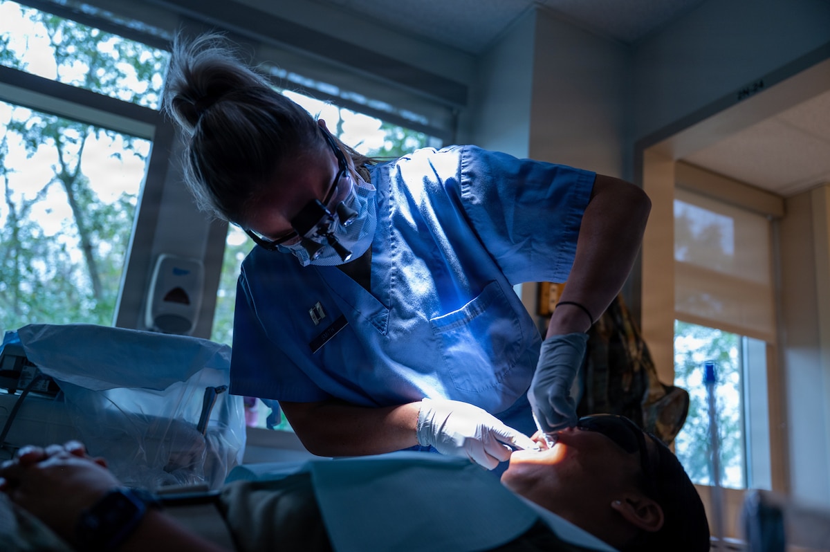 U.S. Air Force Capt. Taylor Smith, general dentist, Maxwell Medical Group, performs an oral examination on a patient at Maxwell Air Force Base, Alabama, Oct. 9, 2025. Air Force members are required to have yearly dental checks to maintain their readiness to deploy. (U.S. Air Force photo by Senior Airman Evan Porter)