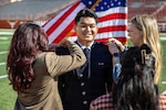 Cadet Kimo Martinez is pinned as a second lieutenant in the U.S. Space Force during Air Force ROTC Detachment 825’s winter 2025 commissioning ceremony at Darrell K Royal–Texas Memorial Stadium in Austin, Texas, on Dec. 21, 2025. Family members pinned on his rank following the Oath of Office administered by his father, retired U.S. Air Force Col. Kato Martinez. The Martinez family survived the 2016 terrorist attack at Brussels Airport, which killed the mother and left several family members injured. (U.S. Air Force photo Ismael Ortega)