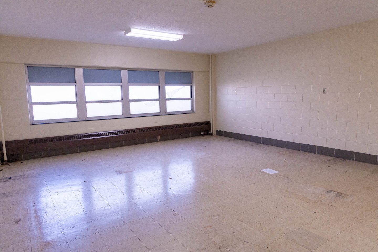 A beige room with a window on the far wall.