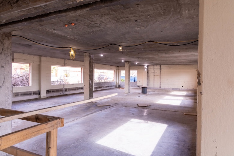 A room under construction with windows, concrete walls and floors.