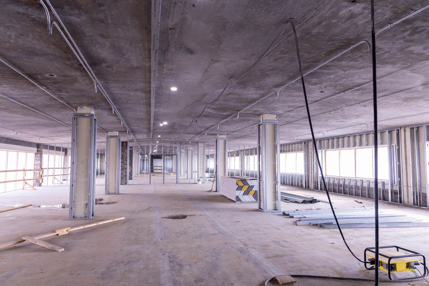 A room under construction with metal framing and concrete floors and ceiling.