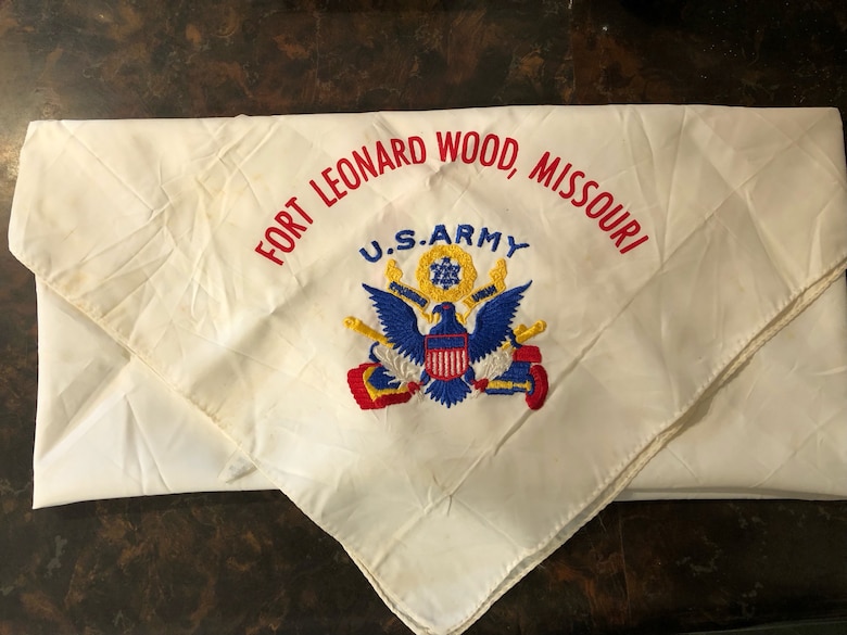 A white scarf with red, blue and yellow stitching.