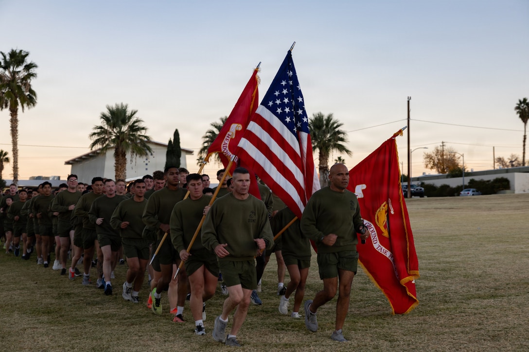 U.S. Marine Corps Maj. Gen. Mark H. Clingan, commanding general of Marine Air Ground Task Force Training Command, Marine Corps Air Ground Combat Center, left, and Sgt. Maj. Roberto Lopez, sergeant major of MAGTFTC, MCAGCC lead the holiday motivational run held at Lance Cpl. Torrey L. Grey Field, MCAGCC, Twentynine Palms, California, Dec. 19, 2025. Marines and sailors of MAGTFTC came together for a holiday motivational run, fostering camaraderie, and boosting morale before the holidays. (U.S. Marine Corps photo by Lance Cpl. Cody Fitzgerald)