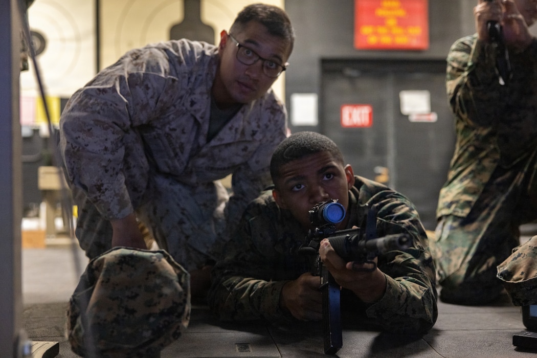 U.S. Marine Corps Lance Cpl. Julio CarrilloGonzalez, a Washington native, machine gunner and combat marksmanship coach with Marksmanship Training Unit, Marine Air Ground Task Force Training Command, Marine Corps Air Ground Combat Center, coaches a Desert Hot Springs Junior Reserve Officer Training Corps student on rifle techniques at MTU, MCAGCC, Twentynine Palms, California, December 12, 2025. MCAGCC welcomed Desert Hot Springs JROTC students for an immersive experience in leadership and mentorship. Students participated in ISMT and various hands-on activities, gaining valuable insights and skills for their future endeavors (U.S. Marine Corps photo by Lance Cpl. Cody Fitzgerald)