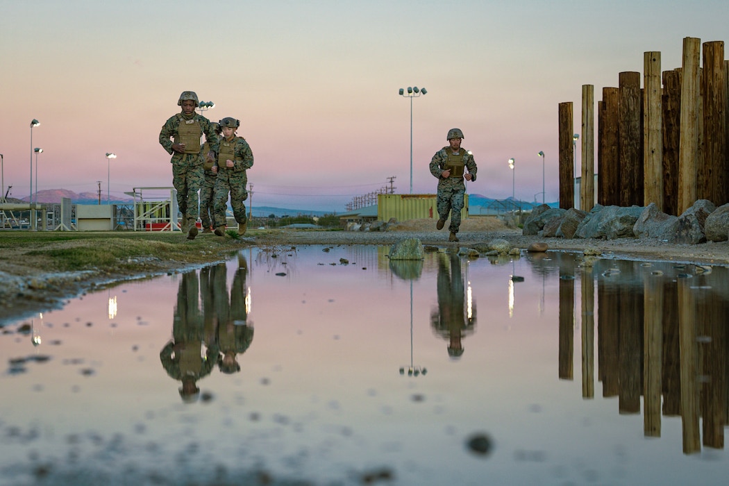 U.S. Marines attending Marine Corps Martial Arts Instructor Course 9-26 conduct a squad run at Marine Corps Air Ground Combat Center, Twentynine Palms, California, Dec. 3, 2025. The MCMAIC certifies Marines to instruct and monitor Marine Corps Martial Arts Program training and advance Marines in the program while testing and strengthening their decision making, warfighting, and leadership skills. (U.S. Marine Corps photo by Lance Cpl. Parker Peichel)