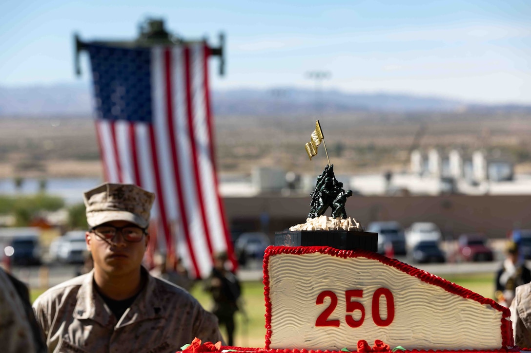U.S. Marines escort the cake for the cake cutting ceremony during the Marine Corps Birthday Pageant, commemorating the 250th Marine Corps Birthday at Lance Cpl. Torrey L. Grey Field, Marine Corps Air Ground Combat Center, Twentynine Palms, California, Nov. 5, 2025. In honor of tradition, the first slice of cake is given to the oldest present Marine followed by the youngest. The birthday pageant is an annual tradition that includes the uniform pageant, as well as the traditional cake cutting ceremony in honor of the Marine Corps’ birthday. (U.S. Marine Corps photo by Lance Cpl. Cody L. Fitzgerald)