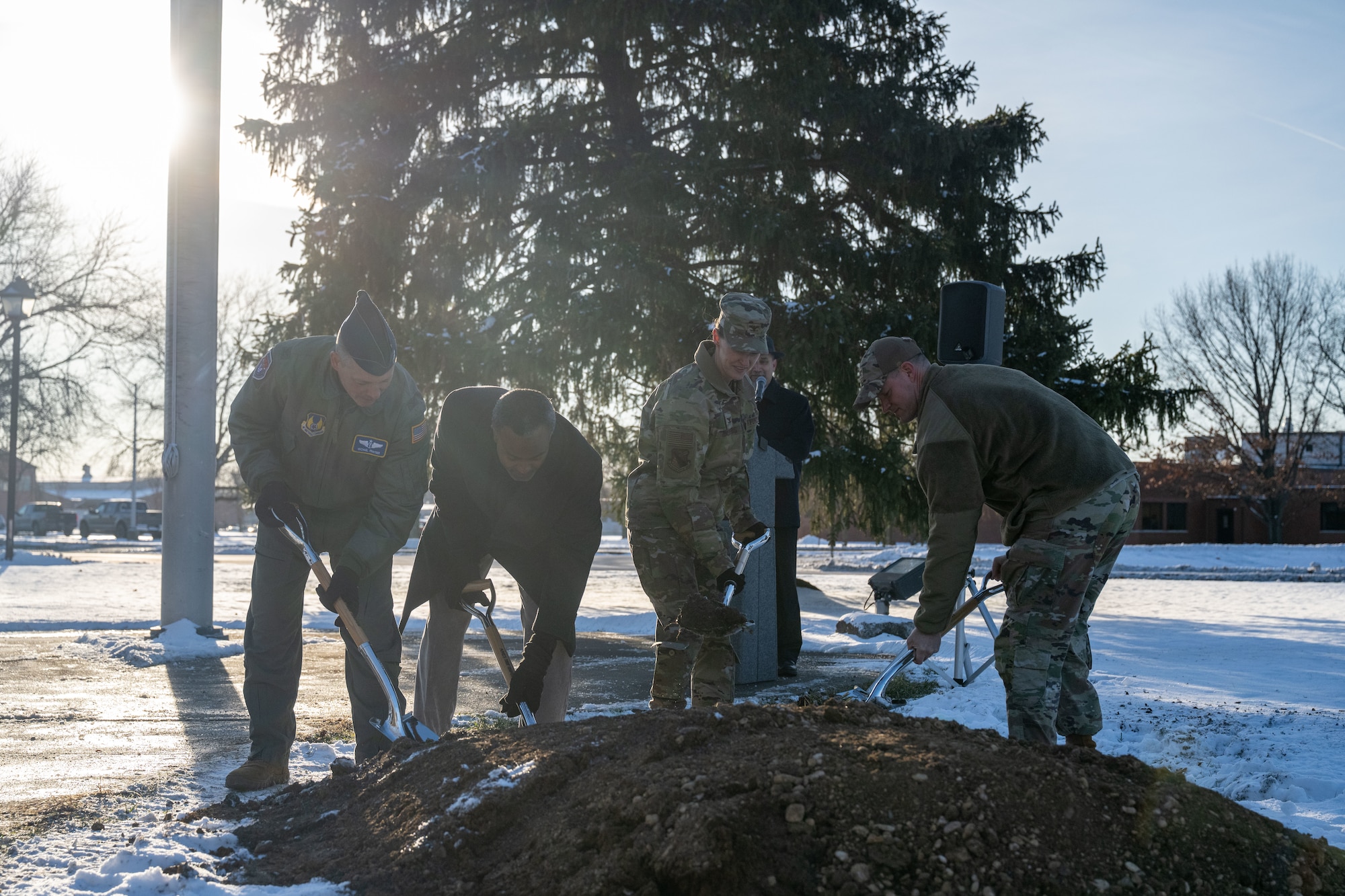 Col. Dustin Richards, 88th Air Base Wing and Installation Commander, Col. Marietta Sanders,  88th Mission Support Group Commander, Col. Michael Frayser, 88th Medical Group Commander, and Amir Mott, 88th Civil Engineering director, get ready to shovel dirt at the 88th Air Base Wing Time Capsule Burial Ceremony Dec. 16, 2025, at Wright-Patterson Air Force Base, Ohio. The event marked the burial of a new time capsule, following the opening of the previous one from 1999 earlier this year. (U.S. Air Force photo by Jack Gardner.)