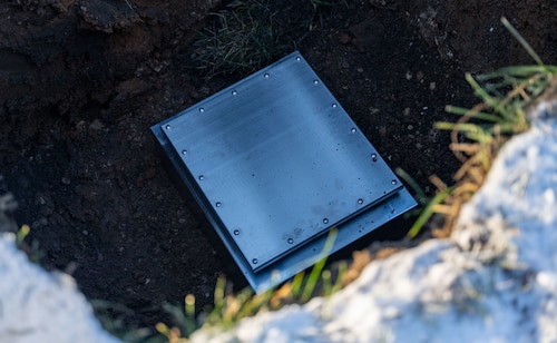 The time capsule at the 88th Air Base Wing Time Capsule Burial Ceremony awaits it's covering Dec. 16, 2025, at Wright-Patterson Air Force Base, Ohio. The event marked the burial of a new time capsule, following the opening of the previous one from 1999 earlier this year. (U.S. Air Force photo by Jack Gardner.)