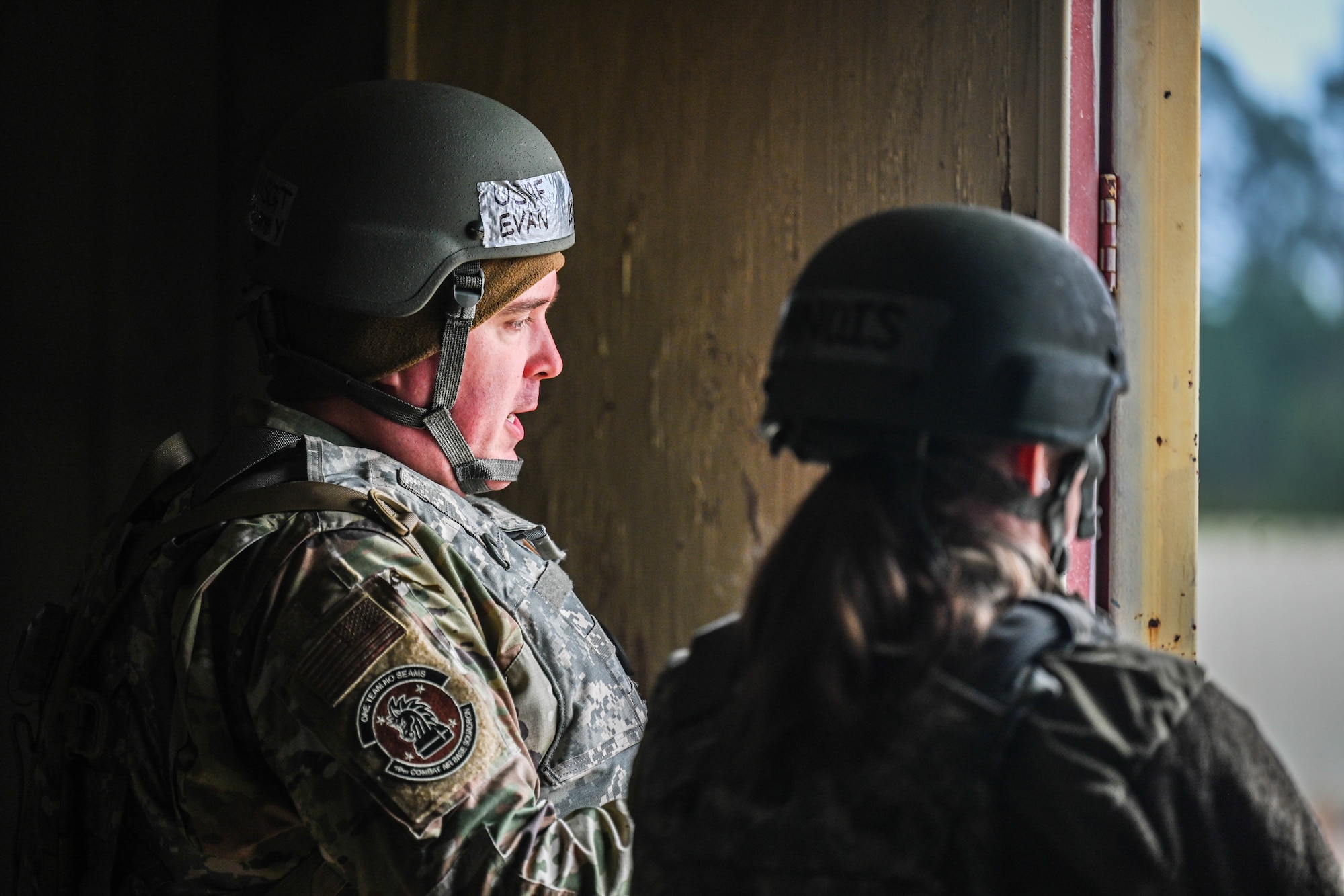 Two Airmen prepare to conduct post-attack actions during a training exercise.