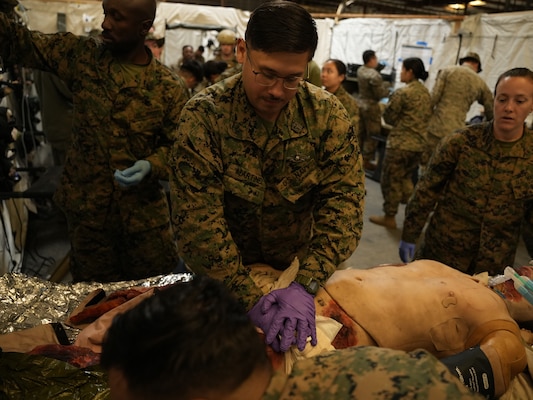 Hospital Corpsman 2nd Class James Martinez, assigned to 1st Medical Battalion, 1st Marine Logistic Group, applies pressure on a simulated inguinal bleed on a simulated patient during an integrated expeditionary training conducted by Naval Expeditionary Medicine Warfighter Development Center (NEMWDC) at Camp Pendleton California, Nov. 18, 2025. The training reinforced hemorrhage control techniques in conjunction with the En Route Care System (ERCS) training to ensure continuity of care during patient transport. (U.S. Navy photo by Petty Officer 2nd Class Kwame Obengyeboah)