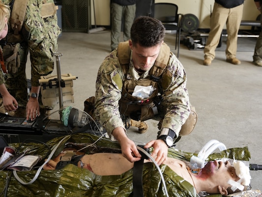 Hospital Corpsman Kristian Jakowicz, a paramedic assigned to En Route Care System (ERCS) 4 from Navy Medicine Readiness and Training Command Guam, secures a simulated patient onto a litter during an integrated expeditionary training conducted by Naval Expeditionary Medicine Warfighter Development Center (NEMWDC) at Camp Pendleton California, Nov. 18, 2025. The course allowed ERCS students to train en route care and patient packaging for evacuation alongside Sailors from 1st Medical Battalion, 1st Marine Logistic Group reinforcing communication, patient handoff procedures, and continuity of care prior to evacuation. (U.S. Navy photo by Petty Officer 2nd Class Kwame Obengyeboah)