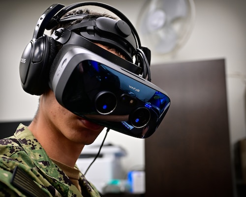 A naval aviation candidate wears a virtual reality (VR) headset equipped with Assessing Spatial Abilities in Naval Aviation (ASANA) to gather data used to aid in the updating and implementation of the Aviation Standardized Test Battery (ASTB) in the Naval Aerospace Medical Institute's (NAMI) behavioral research lab, Aug. 4. ASANA uses eye tracking, motion, bio metric, reaction time, and behavioral monitoring to collect data in order to pair with a user's aptitude testing data to help determine their viability as an aviation officer candidate. With five detachments, 12 training centers, and facilities in over 60 locations across the United States, NMOTC provides high impact individual medical training for the Navy, other U.S. armed forces, and allied nations around the globe. (U.S. Navy photo by Mass Communication Specialist 1st Class Russell Lindsey SW/AW)