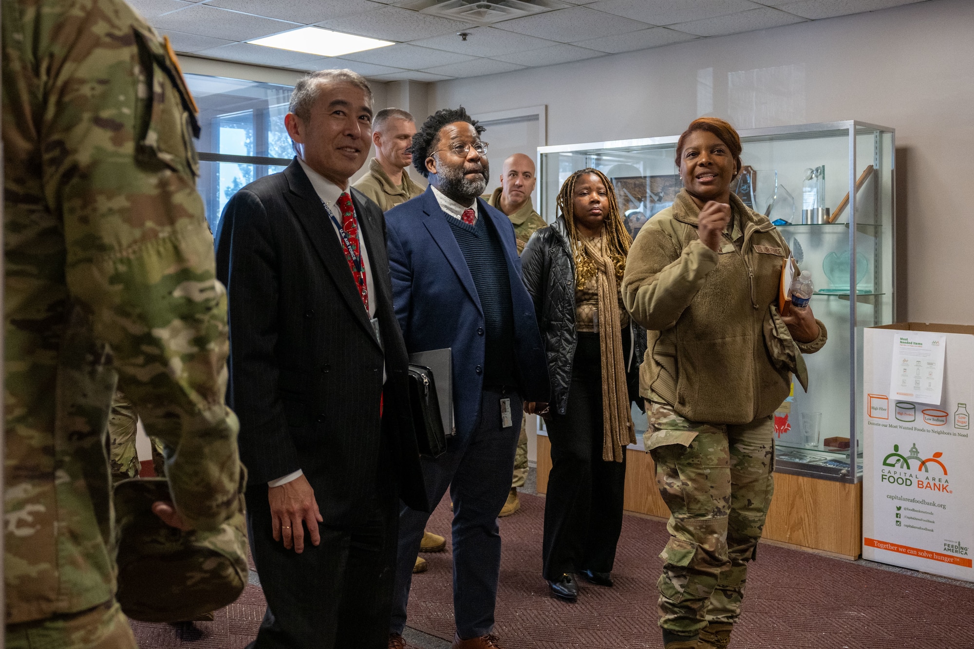 A group of military leaders receives a tour from a colonel.