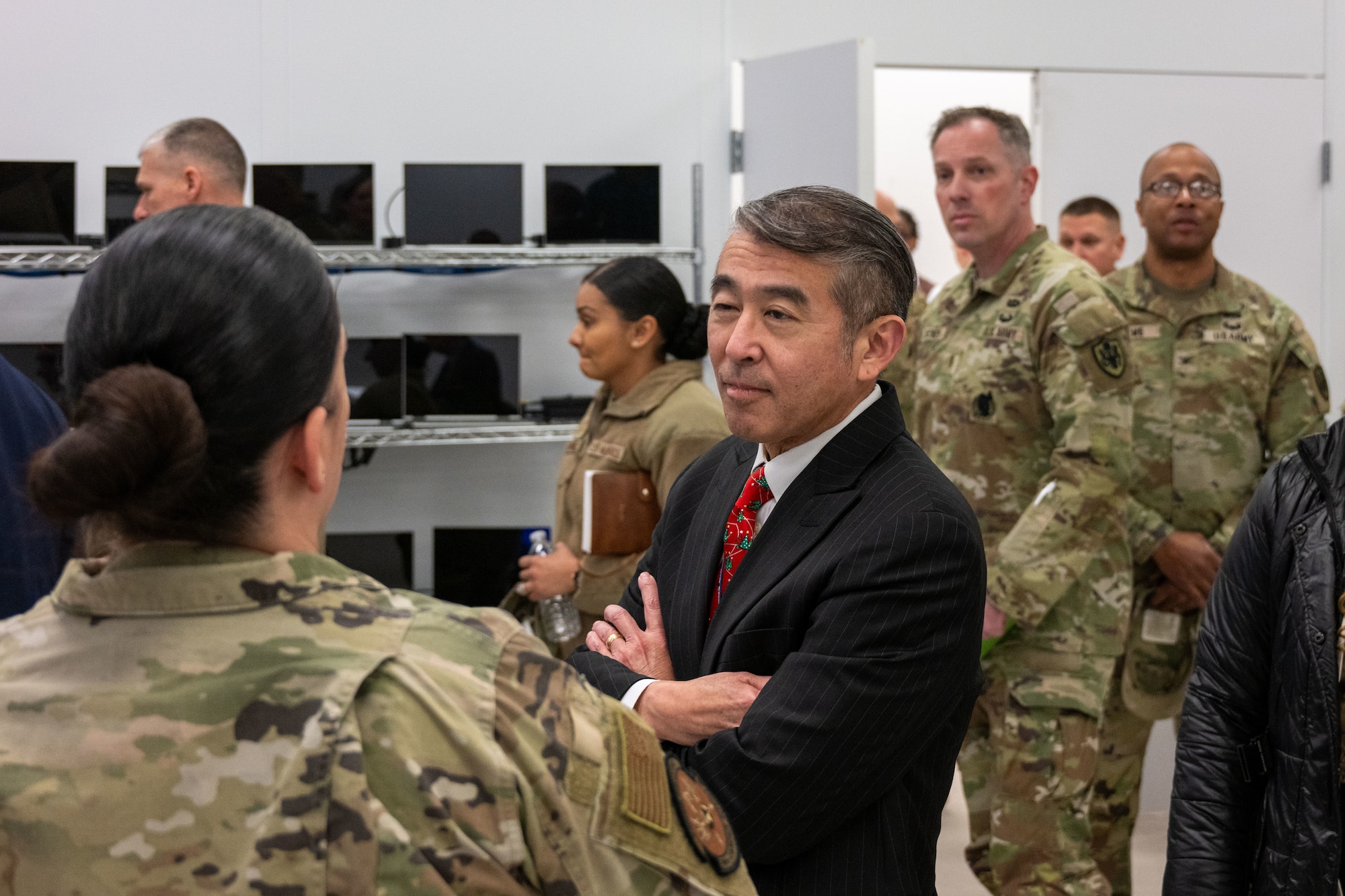 Military leaders tour a room full of computers.