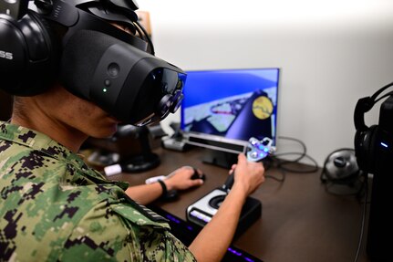 A naval aviation candidate uses a virtual reality (VR) testing station equipped with Assessing Spatial Abilities in Naval Aviation (ASANA) to gather data used in the updating and implementation of the Aviation Standardized Test Battery (ASTB) in the Naval Aerospace Medical Institute's (NAMI) behavioral research lab, Aug. 4. ASANA uses eye tracking, motion, bio metric, reaction time, and behavioral monitoring to collect data in order to pair with a user's aptitude testing data to help determine their viability as an aviation officer candidate. With five detachments, 12 training centers, and facilities in over 60 locations across the United States, NMOTC provides high impact individual medical training for the Navy, other U.S. armed forces, and allied nations around the globe. (U.S. Navy photo by Mass Communication Specialist 1st Class Russell Lindsey SW/AW)