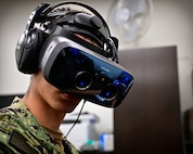 A naval aviation candidate wears a virtual reality (VR) headset equipped with Assessing Spatial Abilities in Naval Aviation (ASANA) to gather data used to aid in the updating and implementation of the Aviation Standardized Test Battery (ASTB) in the Naval Aerospace Medical Institute's (NAMI) behavioral research lab, Aug. 4. ASANA uses eye tracking, motion, bio metric, reaction time, and behavioral monitoring to collect data in order to pair with a user's aptitude testing data to help determine their viability as an aviation officer candidate. With five detachments, 12 training centers, and facilities in over 60 locations across the United States, NMOTC provides high impact individual medical training for the Navy, other U.S. armed forces, and allied nations around the globe. (U.S. Navy photo by Mass Communication Specialist 1st Class Russell Lindsey SW/AW)