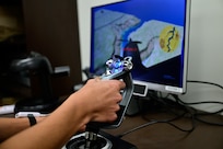 A naval aviation candidate uses a virtual reality (VR) testing station equipped with Assessing Spatial Abilities in Naval Aviation (ASANA) to gather data used in the updating and implementation of the Aviation Standardized Test Battery (ASTB) in the Naval Aerospace Medical Institute's (NAMI) behavioral research lab, Aug. 4. ASANA uses eye tracking, bio metric, reaction time, and behavioral monitoring to collect data in order to pair with a user's aptitude testing data to help determine their viability as an aviation officer candidate. With five detachments, 12 training centers, and facilities in over 60 locations across the United States, NMOTC provides high impact individual medical training for the Navy, other U.S. armed forces, and allied nations around the globe. (U.S. Navy photo by Mass Communication Specialist 1st Class Russell Lindsey SW/AW)