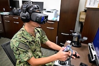 A naval aviation candidate uses a virtual reality (VR) testing station equipped with Assessing Spatial Abilities in Naval Aviation (ASANA) to gather data used in the updating and implementation of the Aviation Standardized Test Battery (ASTB) in the Naval Aerospace Medical Institute's (NAMI) behavioral sciences lab, Aug. 4. ASANA uses eye tracking, bio metric, reaction time, and behavioral monitoring to collect data in order to pair with a user's aptitude testing data to help determine their viability as an aviation officer candidate. With five detachments, 12 training centers, and facilities in over 60 locations across the United States, NMOTC provides high impact individual medical training for the Navy, other U.S. armed forces, and allied nations around the globe. (U.S. Navy photo by Mass Communication Specialist 1st Class Russell Lindsey SW/AW)