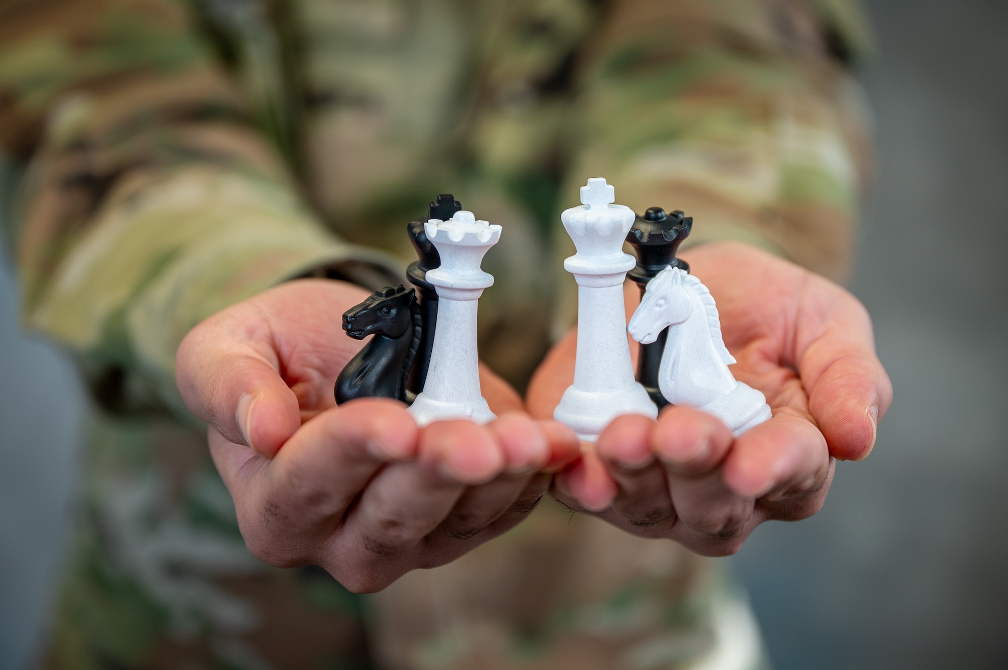 An Airman holding chess pieces in his hands.