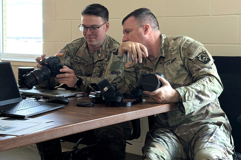 U.S. Army Sgt. 1st Class Brandon Nelson, right, a public affairs specialist with the 109th Mobile Public Affairs Detachment, shows the features and settings of a camera to Sgt. Dave Thomson during a class on photography techniques at their mobilization station at Fort Hood, Texas, Dec. 28, 2025. The unit is preparing to deploy to Europe in support of U.S. Special Operations Command Europe. (U.S. Army National Guard photo by Maj. Travis Mueller)