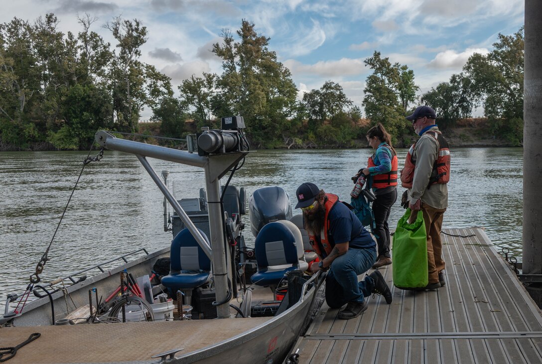 U.S. Army Corps of Engineers Sacramento District team members Greg Jerman, maintenance technician, Ashley Lopez, environmental manager, and David Colby, fisheries biologist, don safety gear before boarding a district boat in preparation for a telemetry survey on Sept. 10, 2025, in Stockton, California. U.S. Army Corps of Engineers Sacramento District environmental managers and Bryte Yard craftsmen collaborate and conduct telemetry surveys to close critical data gaps on green sturgeon passage in the lower Sacramento River, providing valuable information to partner agencies for setting river flow requirements, managing dam releases, and improving the survival of this federally protected species. (U.S. Army photo by Bertha Smith, U.S. Army Corps of Engineers Sacramento District Public Affairs)