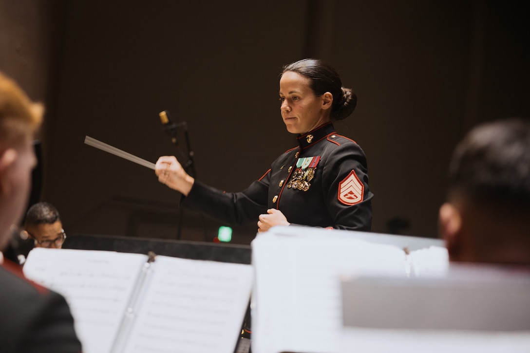 U.S. Marine Corps Staff Sgt. Hannah Ford, enlisted conductor, Marine Band San Diego, Headquarters and Service Battalion, conducts the band during the Annual Holiday Winter Concert at Marine Corps Recruit Depot San Diego, California, Dec. 11, 2025. MCRD San Diego and Western Recruiting Region hosted an annual Winter Concert featuring Marine Band San Diego musicians performing a variety of holiday classics and seasonal favorites for permanent personnel and visitors aboard the installation to celebrate the winter season and build camaraderie. (U.S. Marine Corps photo by Lance Cpl. Janell B. ValerioAlvarez)