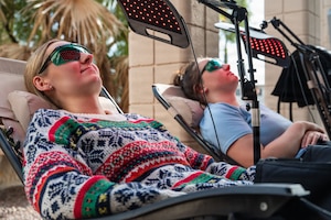 Members of the 355th Force Support Squadron marketing team unwind with compression boots at Davis-Monthan Air Force Base, Arizona, Dec. 23, 2025. The Community Action Team and UNITE program hosted a “Connect 4 Wellness” fair, bringing the Desert Lightning team together for free food, games, and wellness activities to celebrate the holidays. (U.S. Air Force photo by Senior Airman Jasmyne Bridgers-Matos)