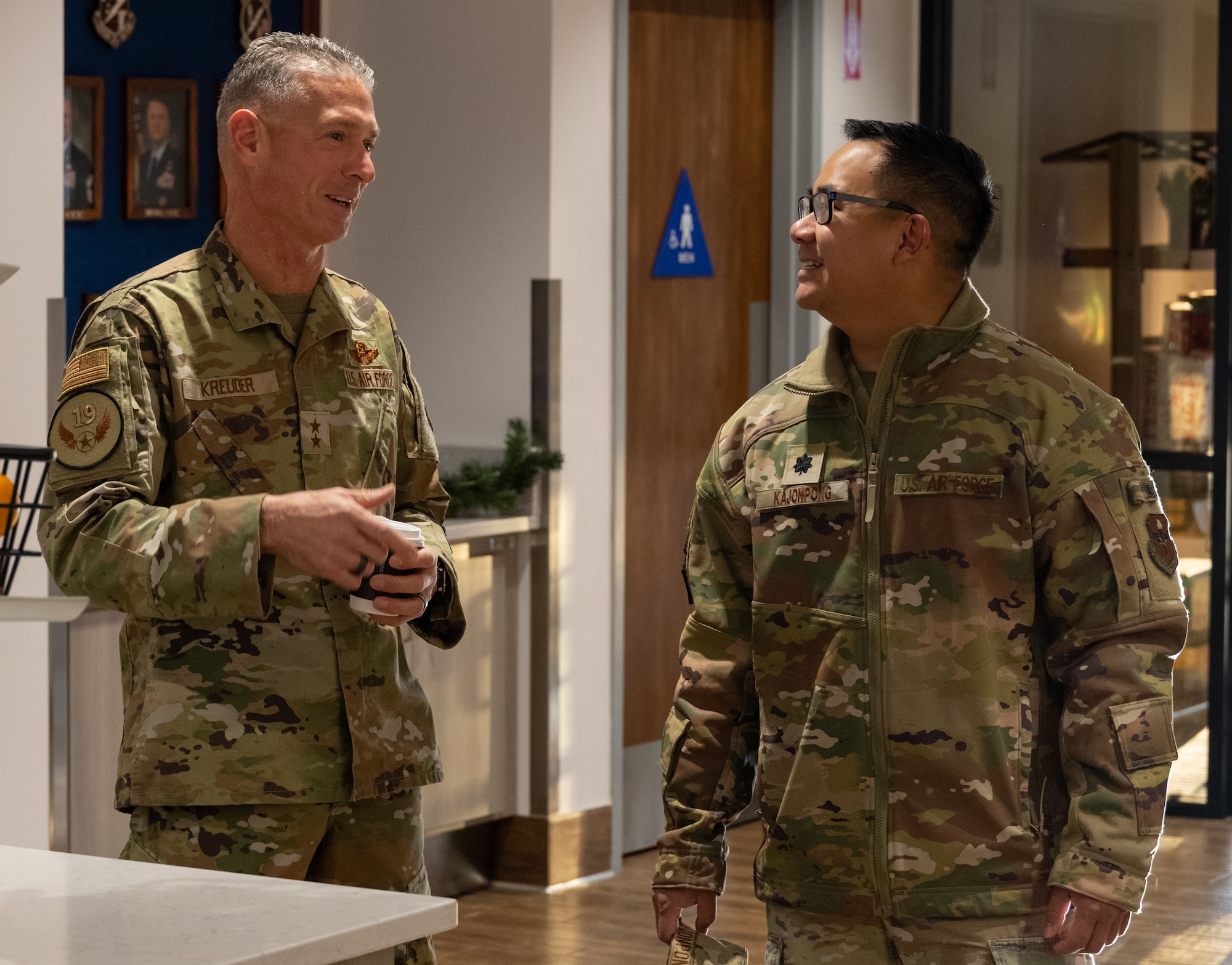U.S. Air Force Maj. Gen. Gregory Kreuder, 19th Air Force commander, left, speaks with Lt. Col. Poonak Kajonpong, 49th Force Support Squadron commander, prior to a breakfast with field grade officers and non-commissioned officers at the Shifting Sands Dining Facility on Holloman Air Force Base, New Mexico, Dec. 17, 2025.