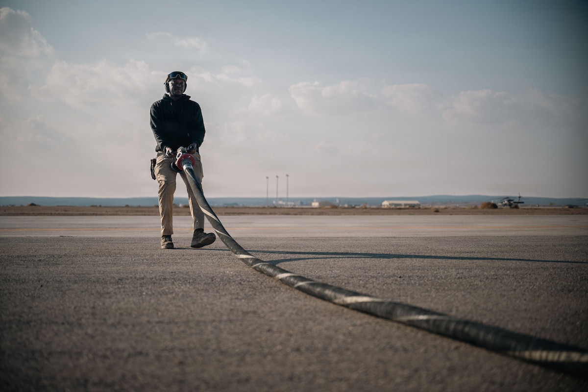U.S. Air Force Airman 1st Class Samuel Ilet, 332nd Expeditionary Logistics Readiness Squadron fuels distribution operator, moves a fuel hose into position in the U.S. Central Command area of responsibility, Dec. 14, 2025.