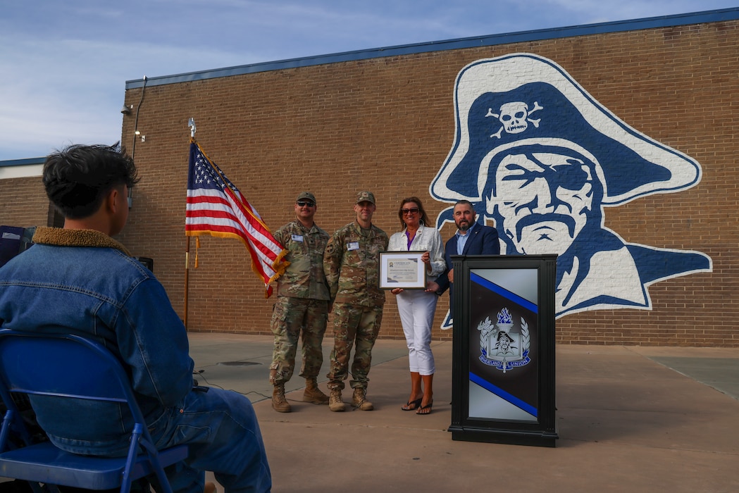 U.S. Air Force Col. Charles Hansen, 9th Mission Support Group commander, and Lt. Col. Dale Ellis, 9th Maintenance Group deputy commander, present a certificate to the principal of Wheatland Union High School for receiving the 2025 Purple Star School honor on April 25, 2025, in Wheatland, California