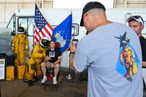 Attendees at the Beale Air and Space Expo take a photo with an Airman in a high pressure suit on Beale Air Force Base, California, June 7, 2025.