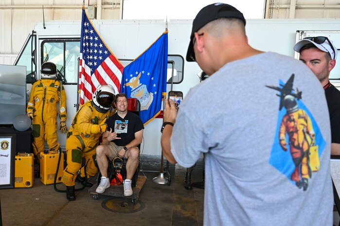 Attendees at the Beale Air and Space Expo take a photo with an Airman in a high pressure suit on Beale Air Force Base, California, June 7, 2025.