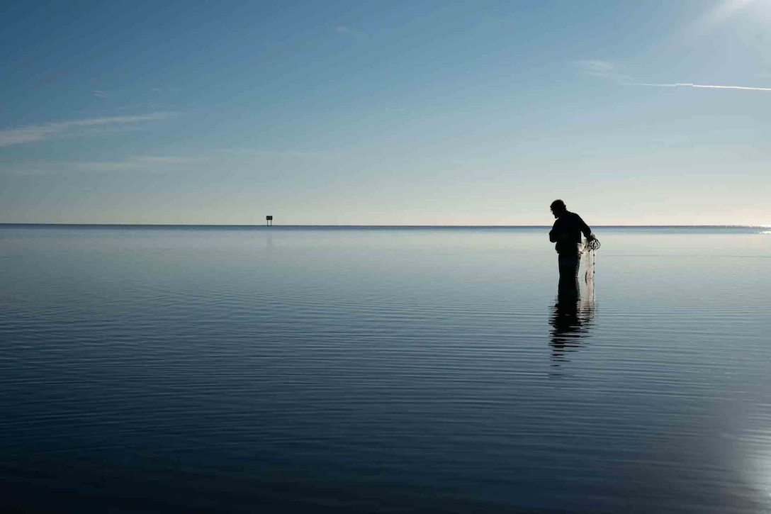 young man casting a fishing net