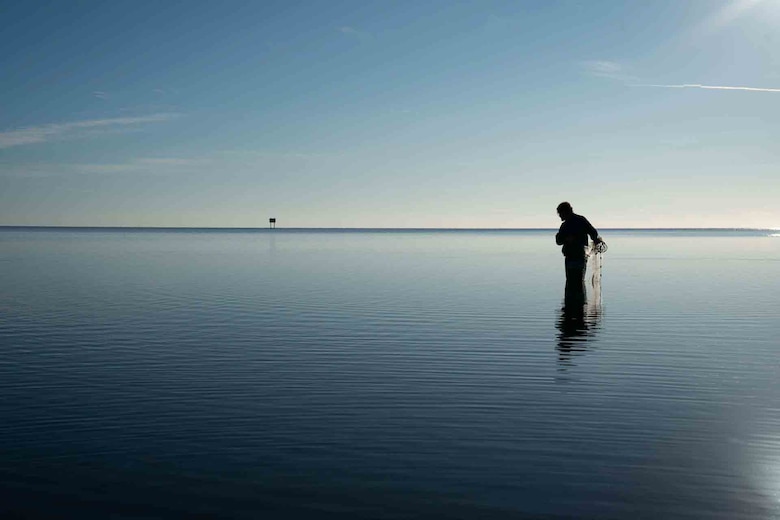 young man casting a fishing net