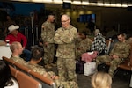 U.S. Army Maj. Gen. Anthony L. McQueen, U.S. Army Medical Center of Excellence commanding general, visits with service members awaiting flights during holiday block leave, also known as exodus, at San Antonio International Airport, Texas, Dec. 20, 2025. The annual joint-service initiative allows trainees from Joint Base San Antonio to travel to approved destinations during the holiday season. (U.S. Air Force photo by Jonathan R. Mallard)