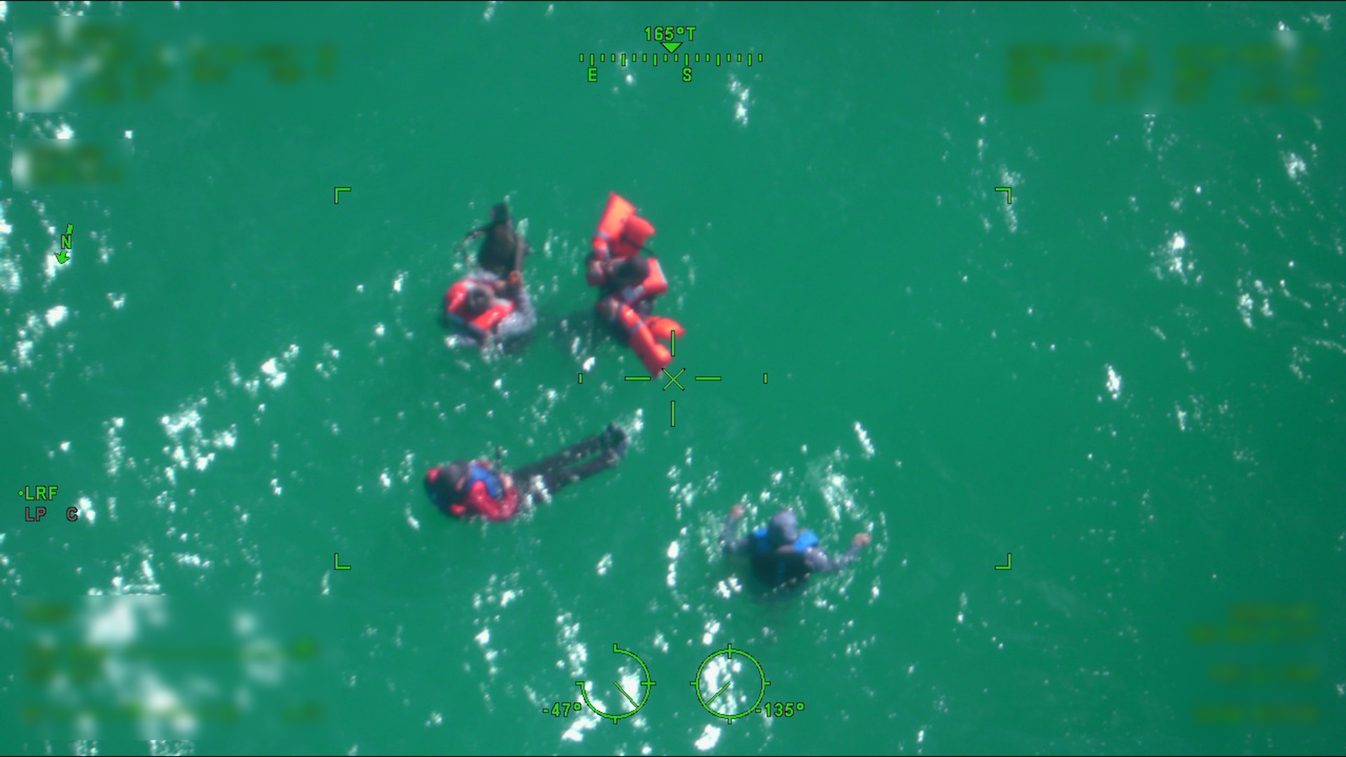 Four survivors of a capsized vessel float in the water approximately 30 miles north of Key West, Florida, Dec. 31, 2025. The boaters tied their life jackets to each other to remain together in the 2 to 4-foot seas. (U.S. Coast Guard photo)