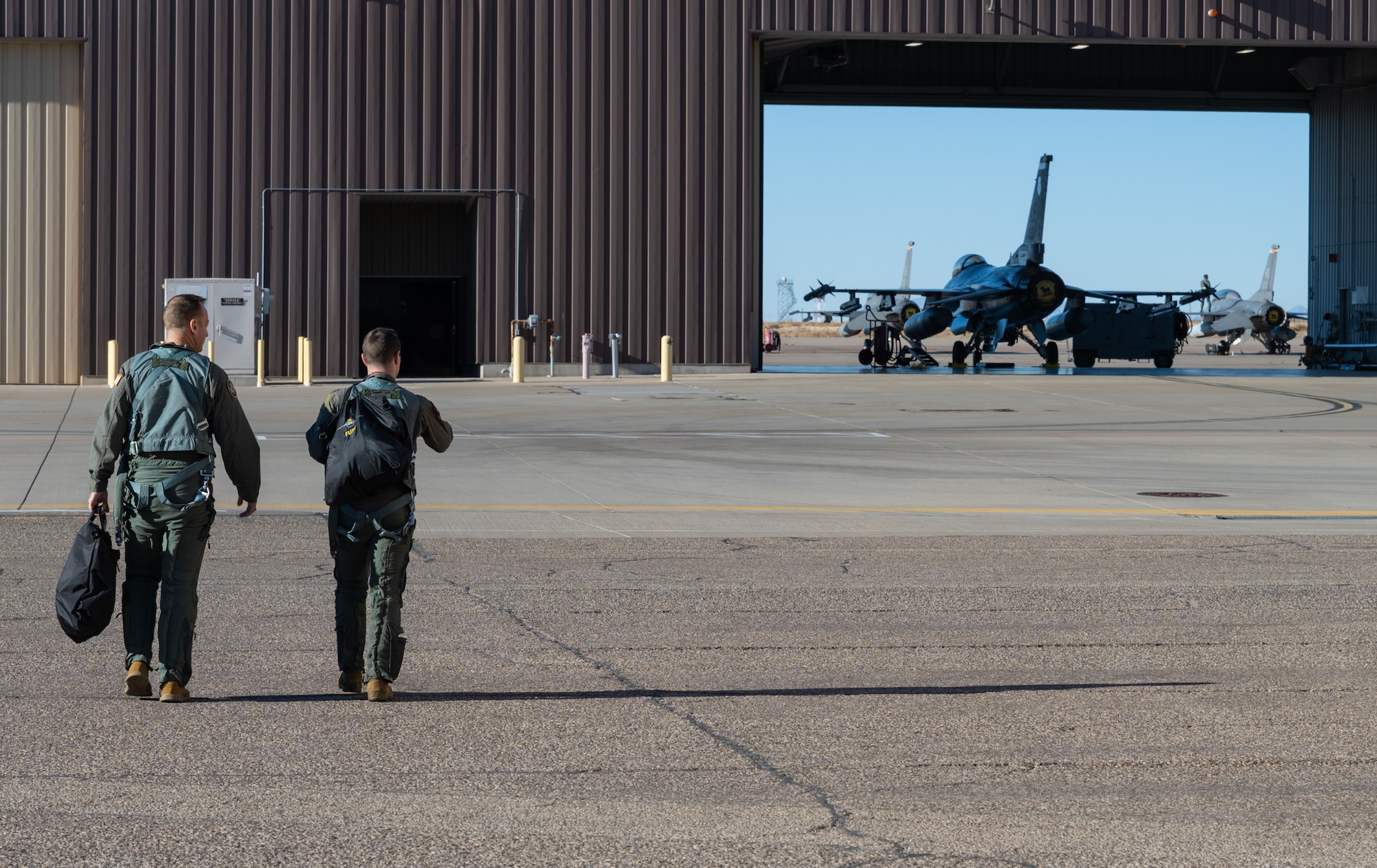 U.S. Air Force Chief Master Sgt. Keith Scott, 19th Air Force command chief, left, and U.S. Air Force Capt. Samuel Galbreath, 314th Fighter Group pilot, step to their jet prior to a sortie on Holloman Air Force Base, New Mexico, Dec. 16, 2025.