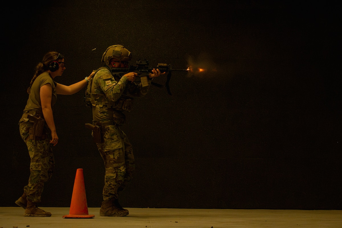 U.S. Air Force Staff Sgt. Alyssa Gallegos, 379th Expeditionary Security Forces Squadron trainer, and Senior Airman Michael Edwards, 379th ESFS defender, conduct a firing course within the U.S. Central Command area of responsibility, Dec. 17, 2025. The training focused on firing while moving to improve accuracy and enhance base defense against real-world threats. (U.S. Air Force photo by Senior Airman Joseph Garcia) 