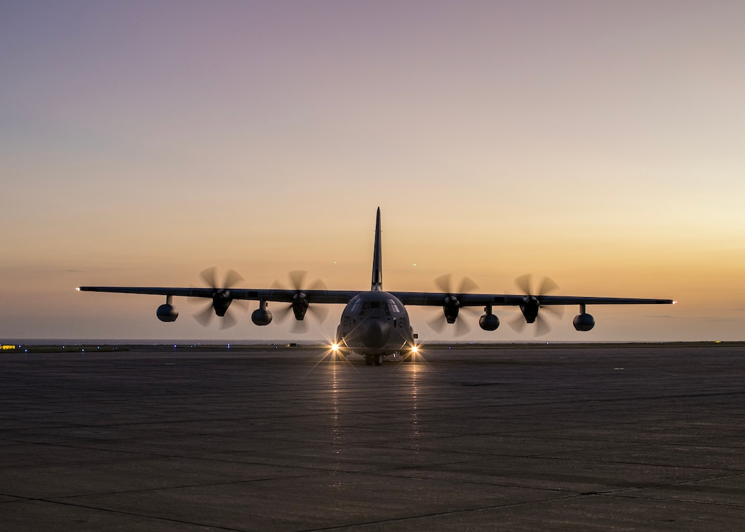 Frontal view of a 4-propeller aircraft taxiing after landing.